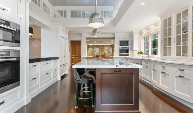 Kitchen with a dark island and white glass-front cabinets — Deep River, CT residence