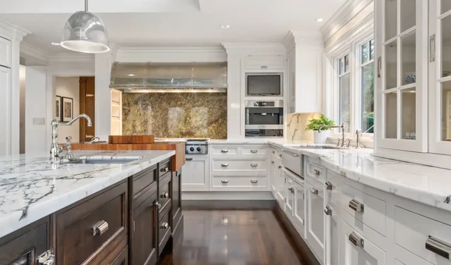 Kitchen with a marble-topped island and brass range backsplash — Deep River, CT residence
