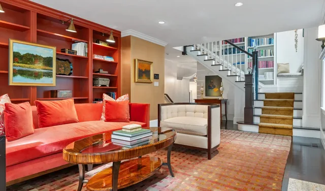 Sitting area with a red sofa, built-in shelves and a staircase — Deep River, CT residence