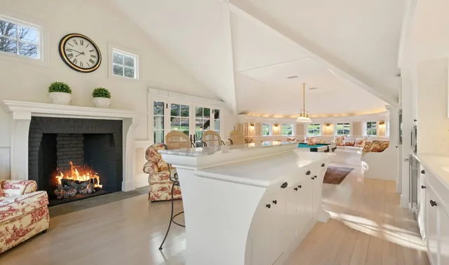 White bar beside a fireplace in a vaulted room — Deep River, CT residence