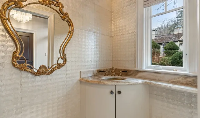 Powder room with a gold-framed mirror and stone countertop — Deep River, CT residence