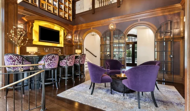 Bar and seating area beneath a gallery balcony — Deep River, CT residence
